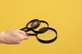 Profile side view closeup of woman hand holding several magnify glasses, loupe.