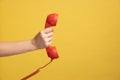 Profile side view closeup of woman hand holding and showing red call telephone handset receiver. Royalty Free Stock Photo