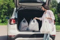 Profile side view of her she nice-looking attractive careful lady packing putting bags in truck pile stack supply visit