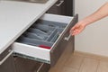 Profile side view photo of part clean white cook table, woman hand open new brown kitchen drawer by modern door handle, with Royalty Free Stock Photo