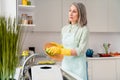 Profile side view portrait of attractive bored grey-haired woman doing dishes neat clean tidy up at home light white