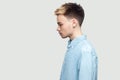 Profile side view portrait of calm serious handsome young man in light blue shirt standing and looking forward with serious face Royalty Free Stock Photo