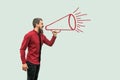 Profile side view portrait of handsome bearded man in red shirt standing and shouting on drawed megaphone