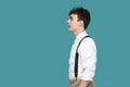 Profile side view portrait of happy handsome hipster curly young businessman in classic casual white shirt and suspender standing Royalty Free Stock Photo