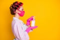Profile side view portrait of maid wearing safety mask using liquid soap sanitizer isolated on bright yellow color