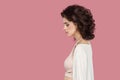 Profile side view portrait of sad beautiful brunette young woman with curly hairstyle in casual style standing, holding her head Royalty Free Stock Photo