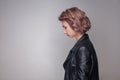 Profile side view portrait of sad depressed beautiful girl with short hairstyle, makeup in casual style black leather jacket Royalty Free Stock Photo