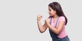 Profile side view portrait of serious or angry young girl in pink t-shirt and blue overalls standing with fists boxing hands and