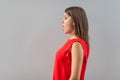Profile side view portrait of shocked beautiful brunette young woman in red shirt standing, looking forward with surprised Royalty Free Stock Photo