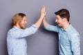 Profile side view portrait of two nice attractive glad cheerful cheery guys best buddy fellow clapping palms deal done