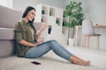 Profile side view of pretty cheerful girl sitting on carpet using laptop making video call having fun pastime at home Royalty Free Stock Photo