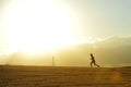 Profile silhouette of young man running in countryside training cross country jogging discipline in summer sunset Royalty Free Stock Photo