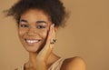 Profile of smiling afro american woman demonstrating rings on her fingers, keeping hands at face Royalty Free Stock Photo