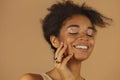 Profile of smiling afro american woman demonstrating rings on her fingers, keeping hands at face Royalty Free Stock Photo