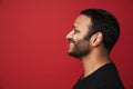 Profile of smiling indian man looking away isolated over red background Royalty Free Stock Photo