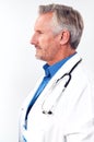 Profile Studio Shot Of Mature Male Doctor Wearing White Coat And Stethoscope On White Background