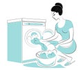 Profile of a sweet lady. The girl is washing on the washing machine, laying dirty laundry. A woman is a good wife and a neat