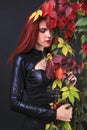 Profile of a tall red head gothic woman among the autumn vines