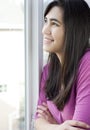 Profile of teen girl looking out window