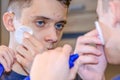 Profile of a teenager looking at his face in the mirror. Problems of the skin. Royalty Free Stock Photo