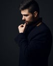 Profile of thoughtful bearded businessman modern intellectual in jacket holding hand at chin looking down Royalty Free Stock Photo