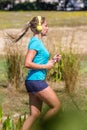 Profile view of blond woman running in listening to music Royalty Free Stock Photo