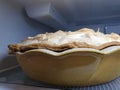 Profile view browned merengue on homemade pie crust in antique stoneware baking dish