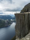 Profile view of famous Preikestolen massive cliff at fjord Lysefjord, famous Norway viewpoint with group of tourists and