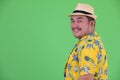 Profile view of happy young overweight Asian tourist man smiling