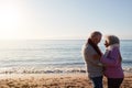 Profile View Of Loving Retired Couple Hugging Standing By Sea On Winter Beach Vacation Royalty Free Stock Photo