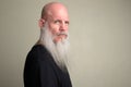 Profile view of mature bald man with long gray beard looking at camera Royalty Free Stock Photo