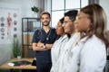 Multiracial group of medical interns in lab coats standing in a row at modern light clinic room Royalty Free Stock Photo