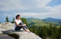 Young woman resting on a big stone in the summer day in the Carpathian mountains Royalty Free Stock Photo