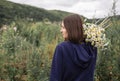 Profile view of young woman holding bouquet of daisies on her shoulder Royalty Free Stock Photo