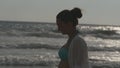 Profile of woman in bikini and shirt walking on the beach near the ocean at evening. Young beautiful girl enjoying life Royalty Free Stock Photo