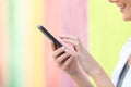 Profile of a woman hand using cell phone in a colorful street Royalty Free Stock Photo