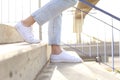 Profile of woman legs wearing sneakers walking down stairs