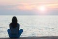 Profile of a woman silhouette watching sun on the beach