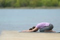 Yogi doing yoga exercise in a lake pier