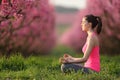 Profile of a yogi doing yoga in pink in a field