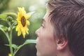 Profile of a young man looking at a sunflower Royalty Free Stock Photo