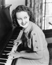 Profile of a young woman playing a piano and smiling