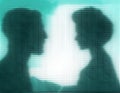 Profiles of man and woman behind blue glass Royalty Free Stock Photo