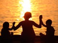 Profiles of mother and children at sunset