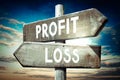 Profit, loss - wooden signpost, roadsign with two arrows Royalty Free Stock Photo