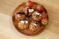 Profiterole, cream puff cakes filled with whipped cream with strawberries