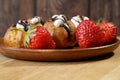 Profiterole, cream puff cakes filled with whipped cream with strawberries