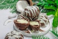 Profiteroles choux pastry buns with coconut cream served in tropical style. Palm leaves Royalty Free Stock Photo