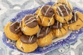 Profiteroles, coated in chocolate, stacked on a pattermed blue and white plate. Royalty Free Stock Photo