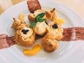 Profiteroles with cream and orange slices closeup Royalty Free Stock Photo